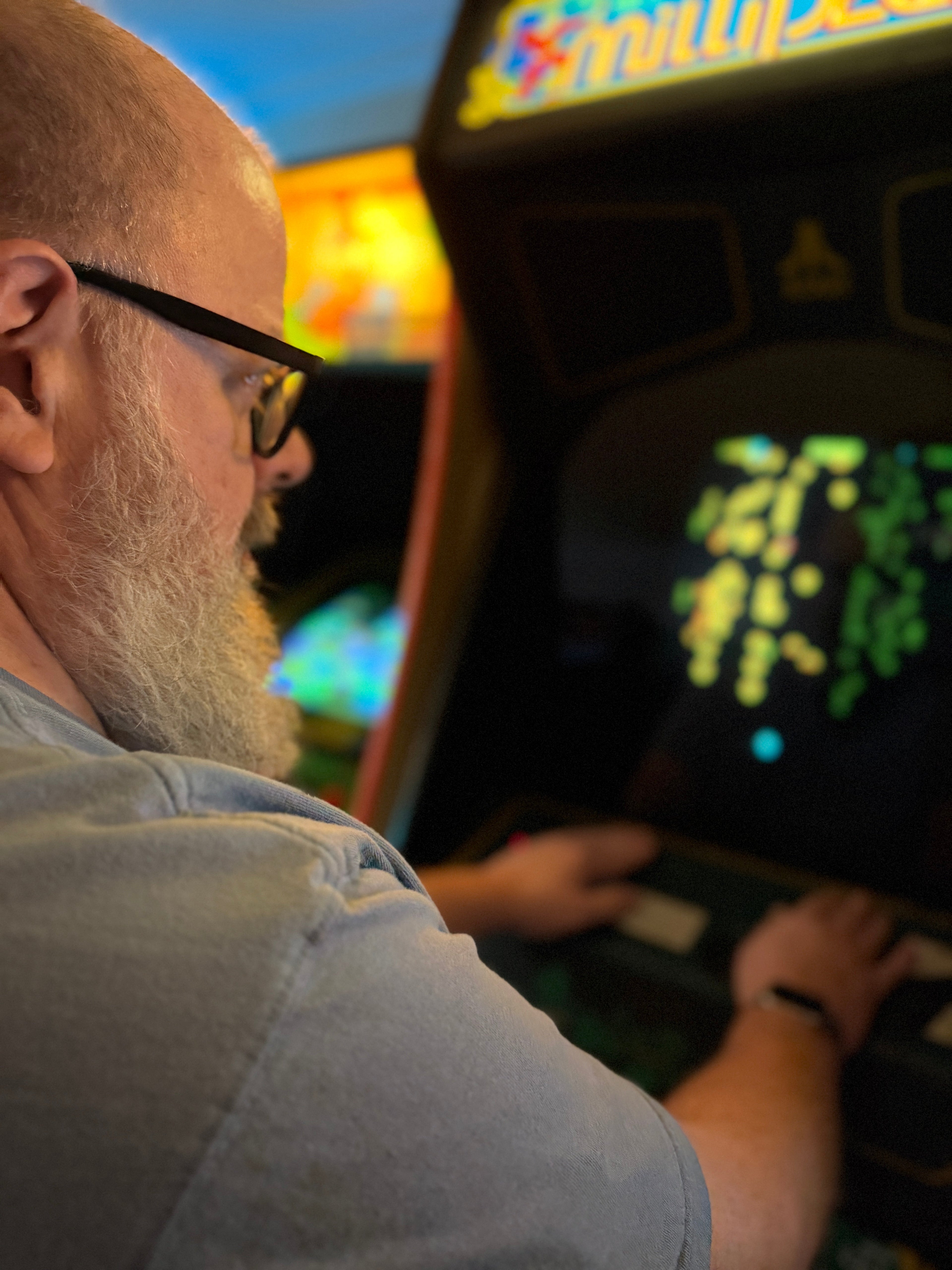 Jeffrey playing Centipede on a Millipede arcade cabinet, hands on the trackball