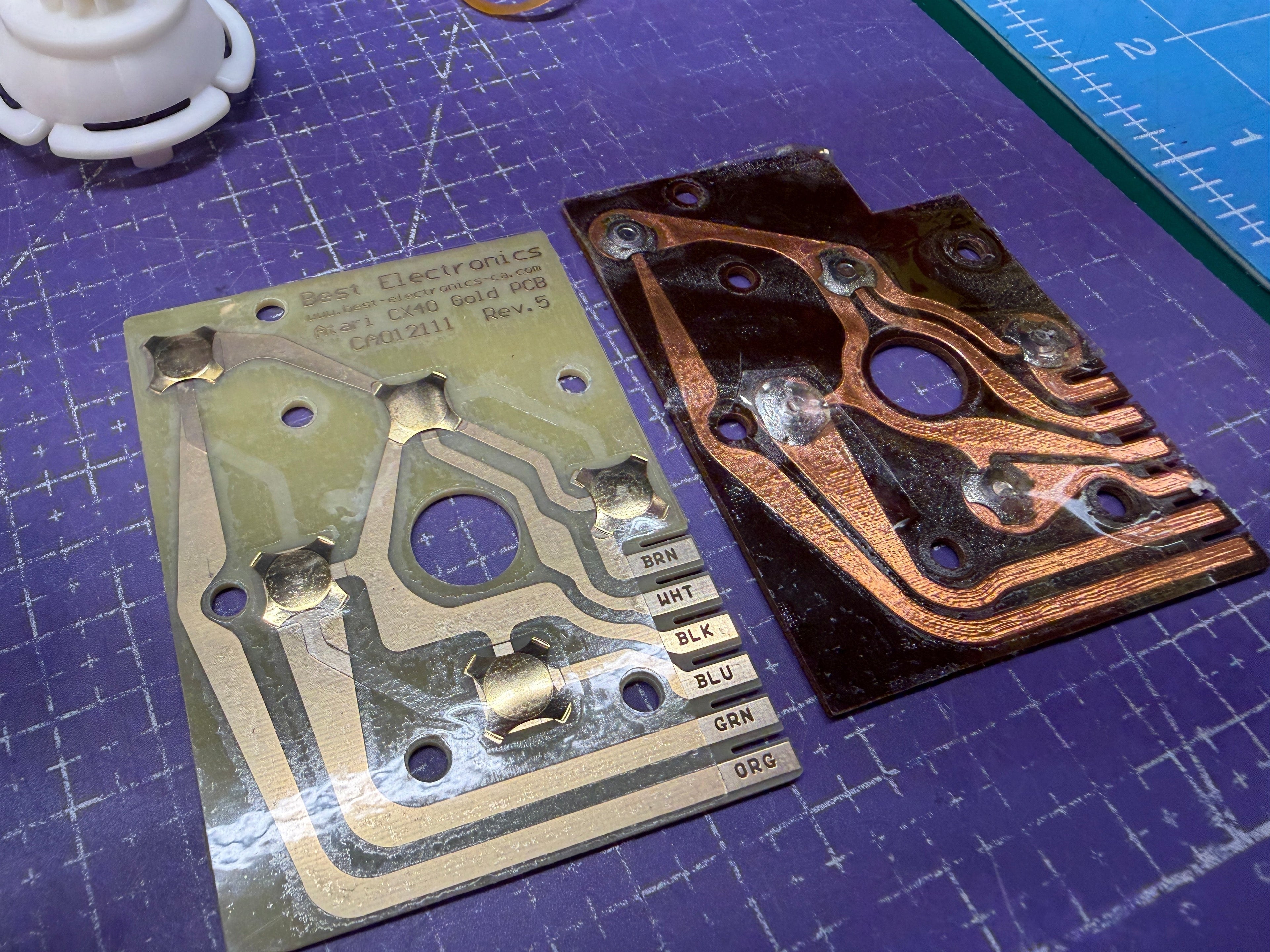 New gold-plated BEST Electronics CX40 upgrade PCB beside the darkened, worn original Atari contact board.