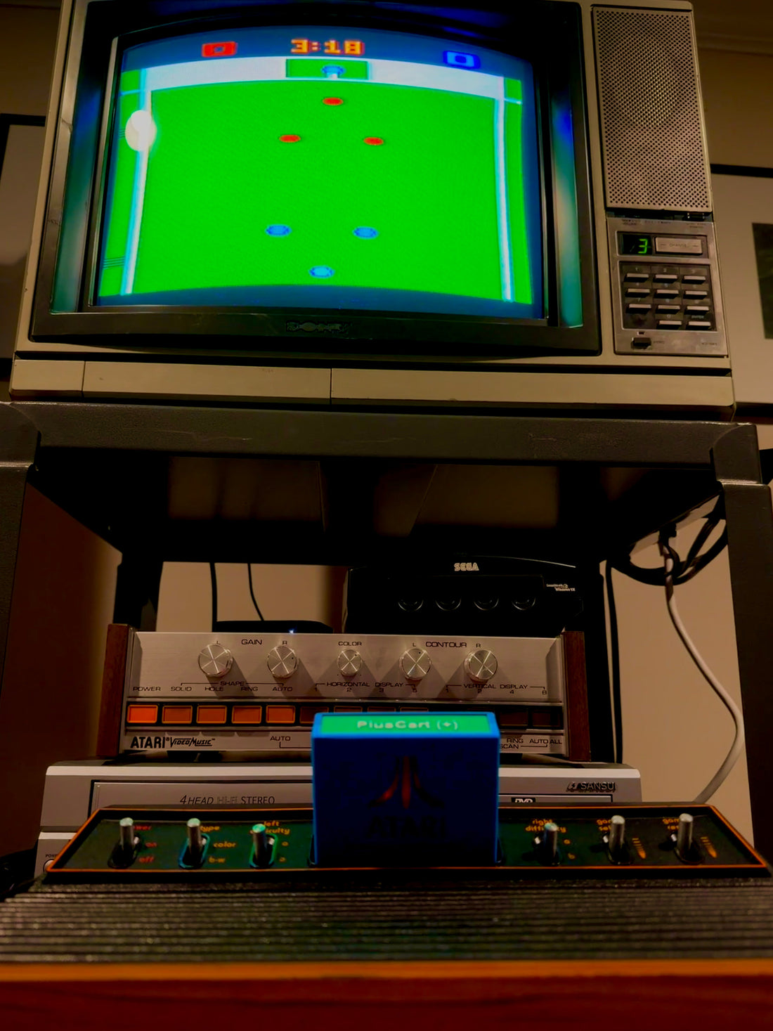 Atari 2600 with a PlusCart+ cartridge running Championship Soccer on a CRT, match clock onscreen.