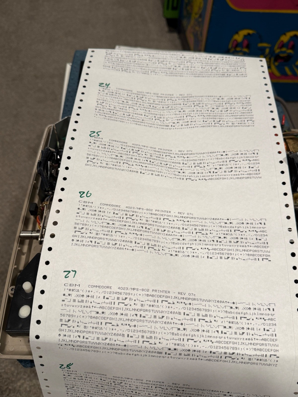 MPS-802 self-test printouts on continuous-feed paper, each labeled with a chip tracking number, showing the character set and graphics output that confirms the Grafik ROM II upgrade works on real hardware